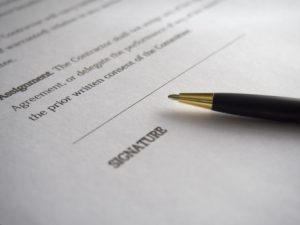 close up of a pen sitting on a contract