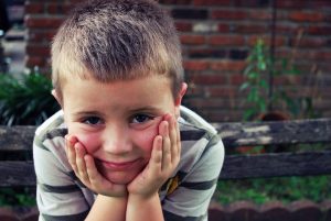 little boy sitting with his chin in his hands