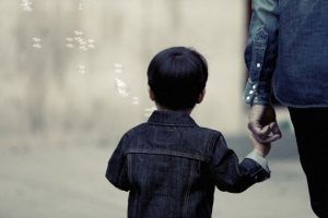 child holding hands with parent and blowing bubbles