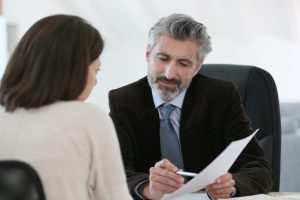 woman looking over documents with a lawyer