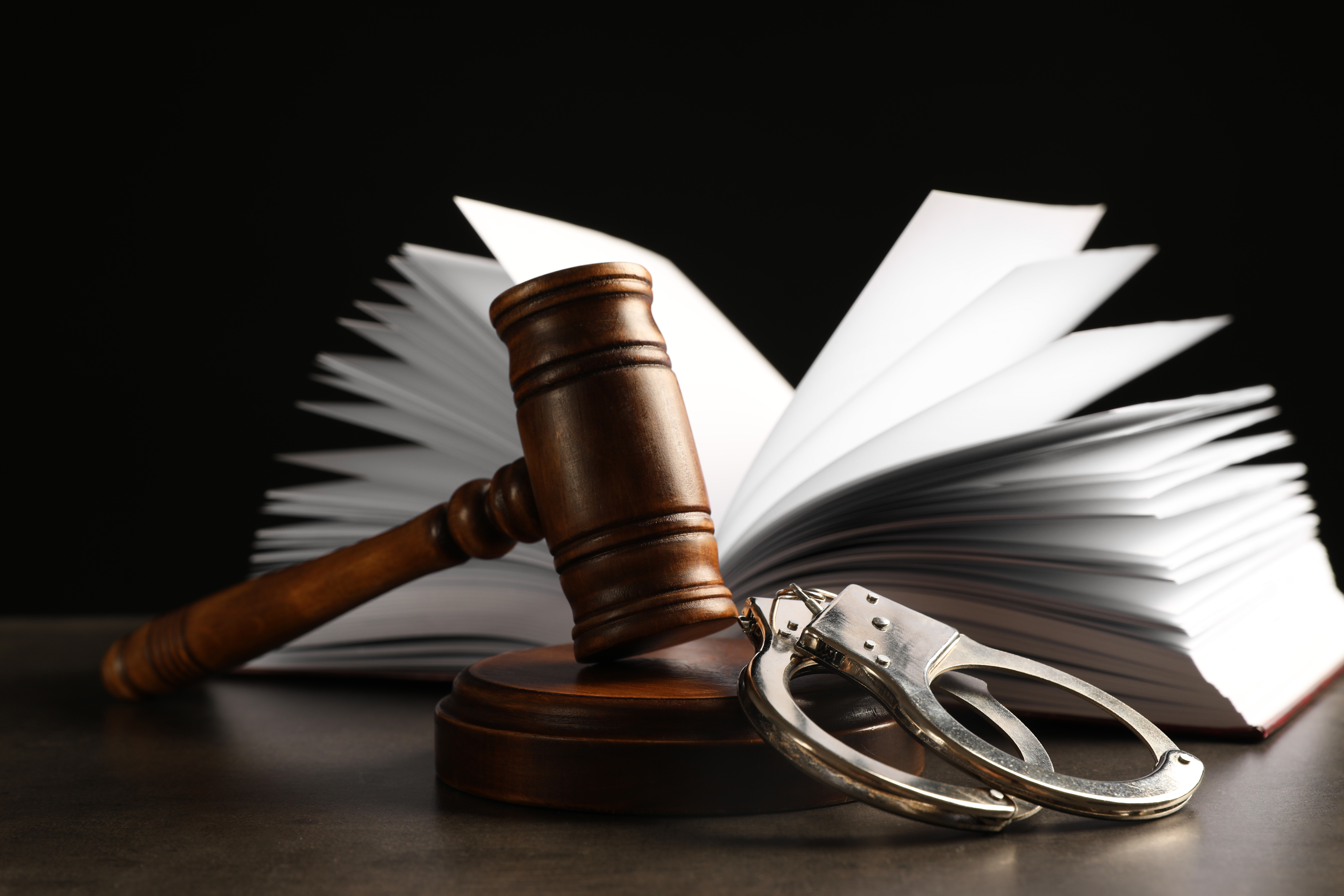 Gavel handcuffs and law book representing assault battery defense options in Tampa
