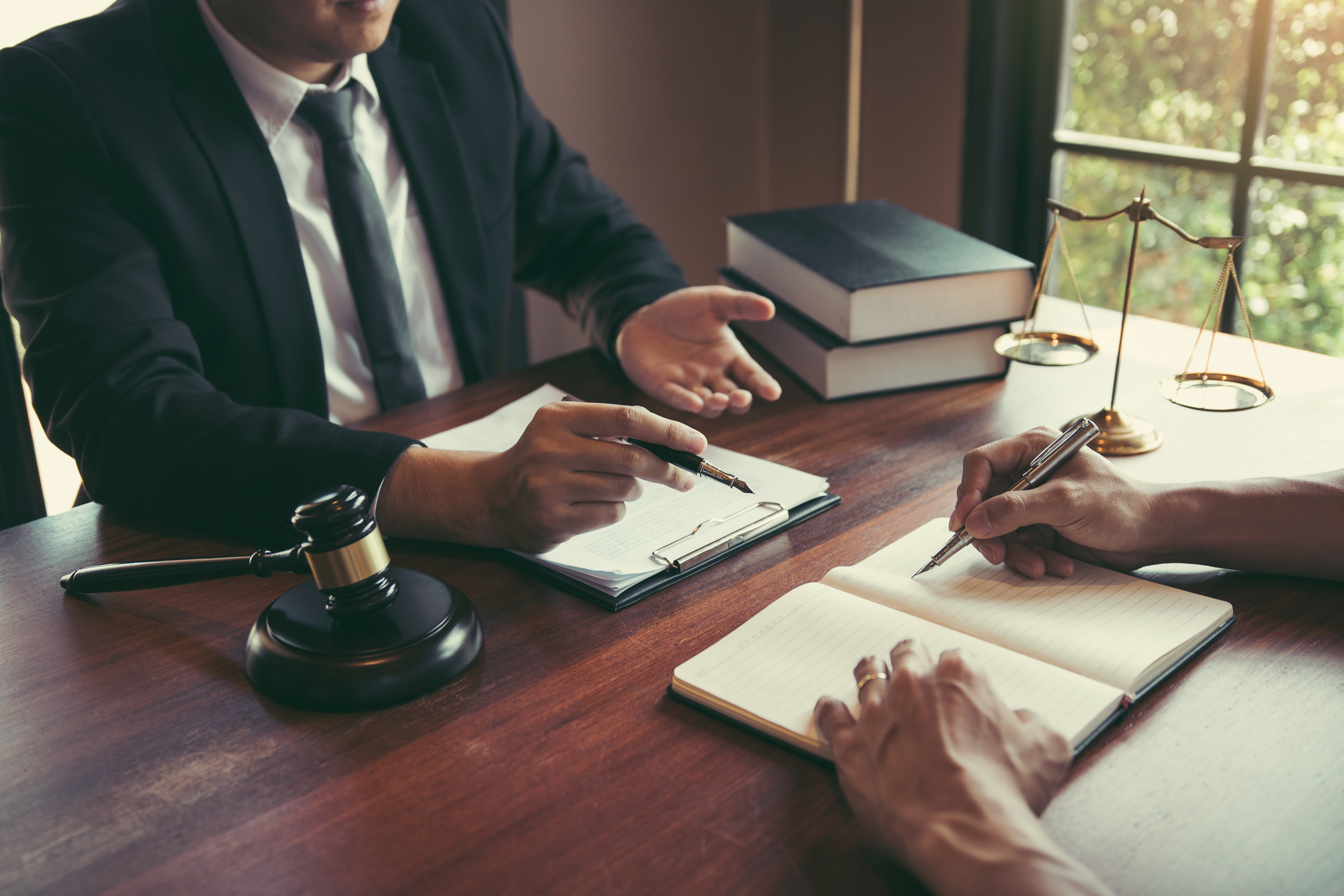 Two attorneys collaborating on injunction defense Tampa legal strategy at their workplace